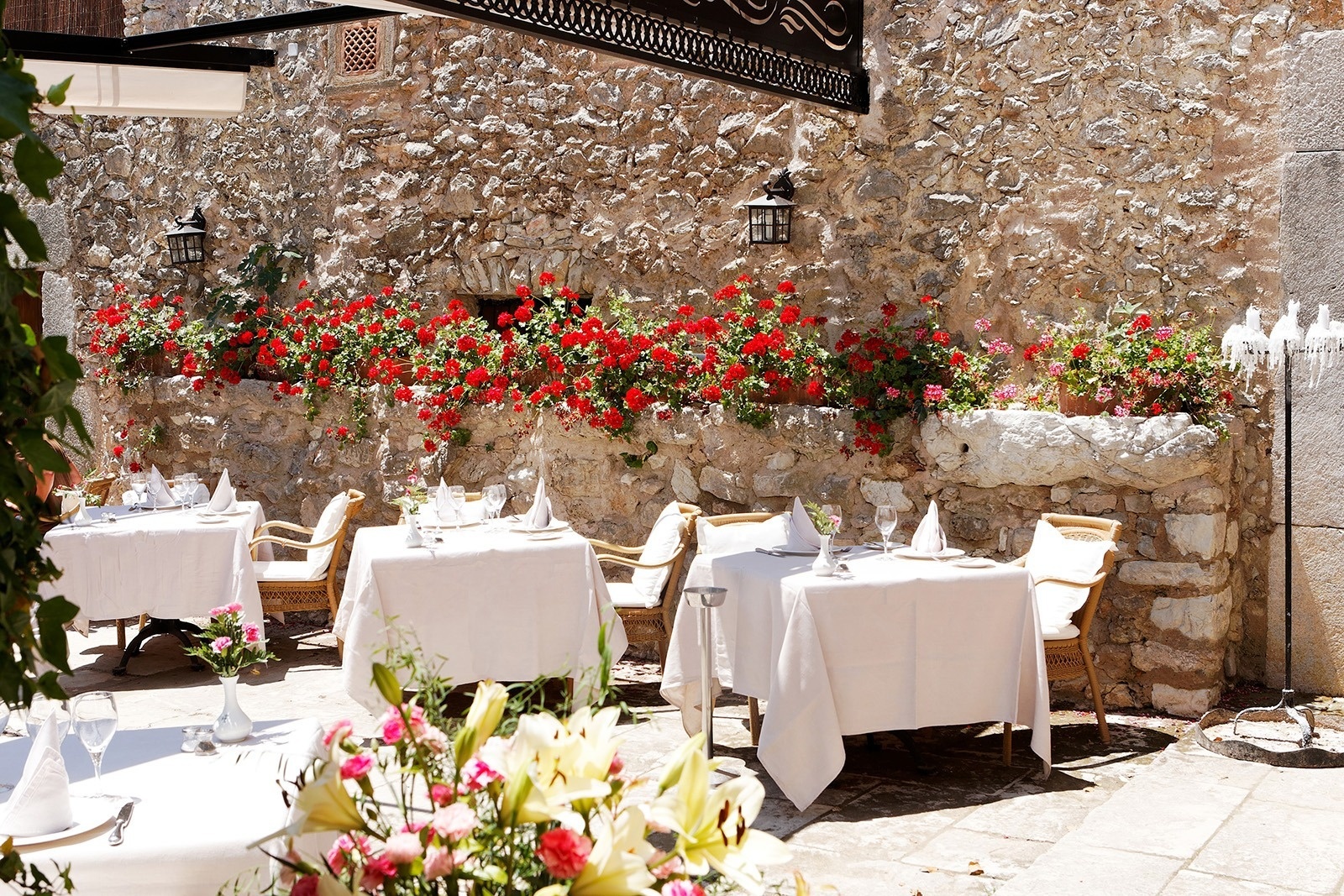 un restaurante con mesas y sillas frente a una pared de piedra