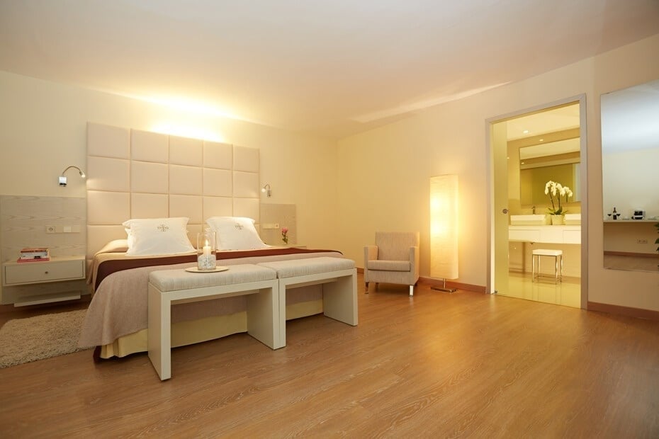 un dormitorio con una cama y una silla y una puerta que conduce a un baño