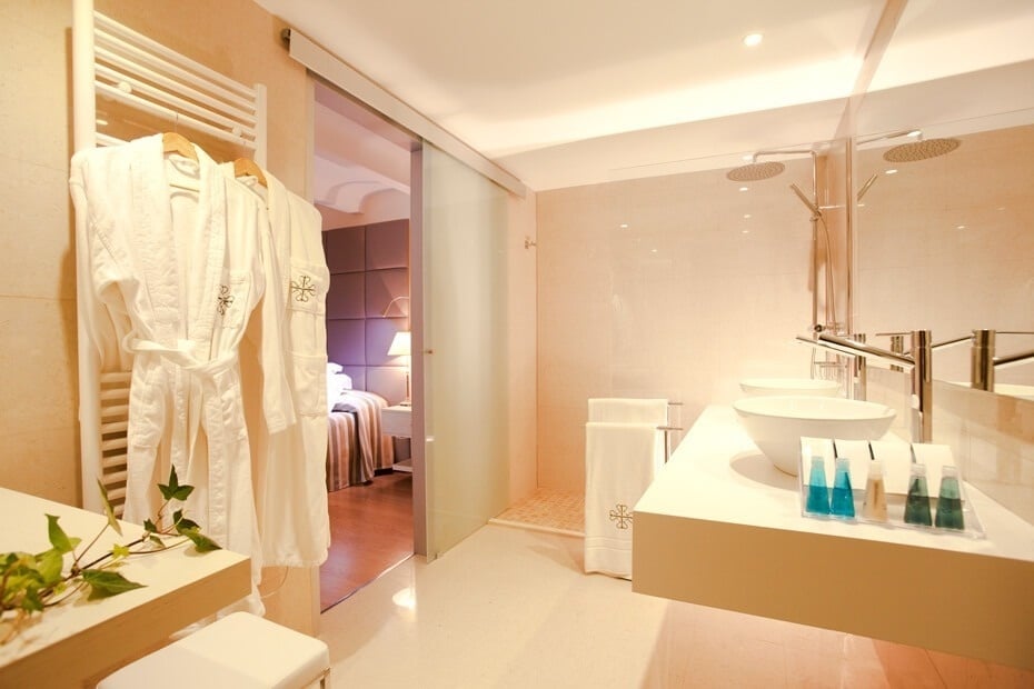 un baño con dos lavabos y una puerta corrediza de vidrio