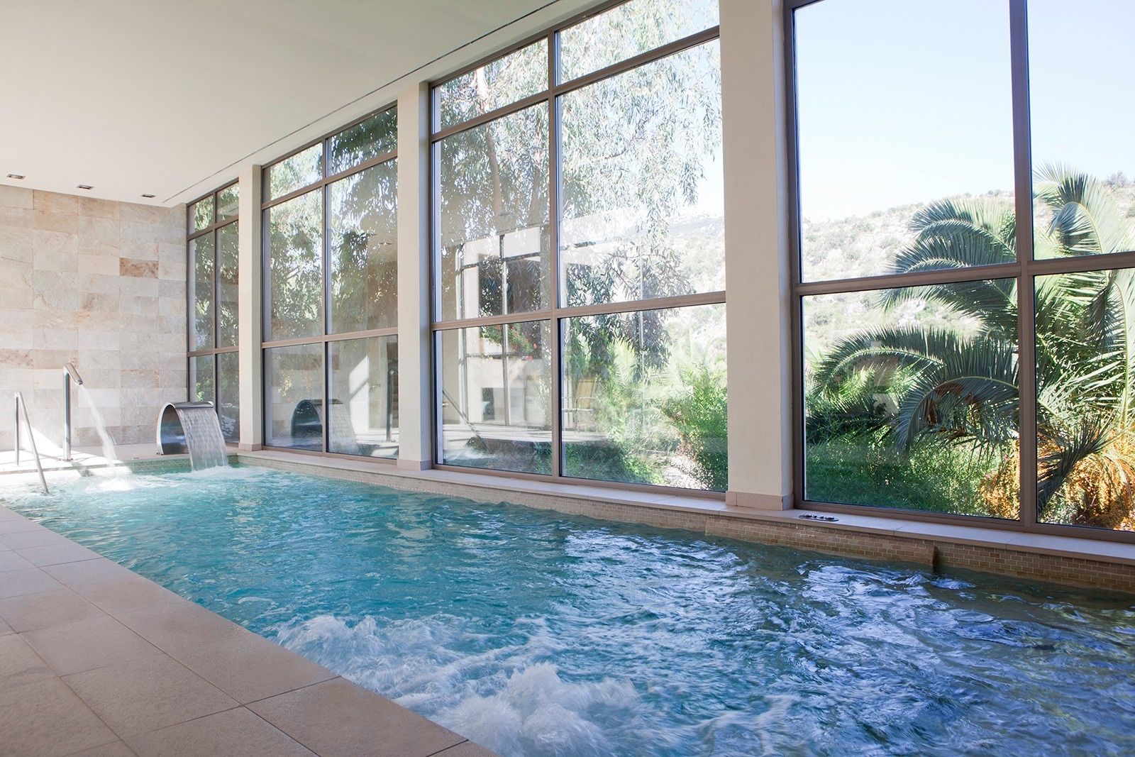 una piscina dentro de una casa con muchas ventanas