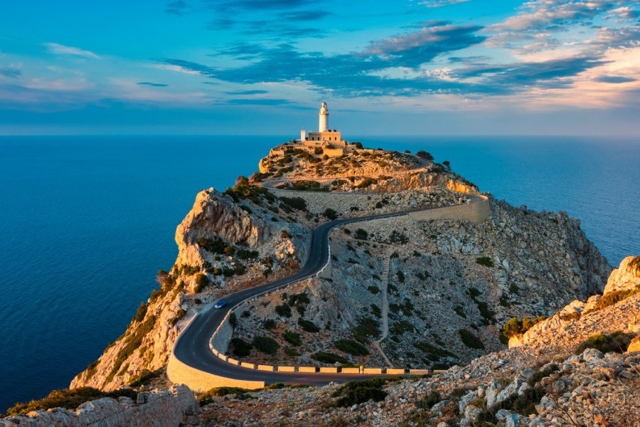 una carretera que conduce a un faro en la cima de una montaña