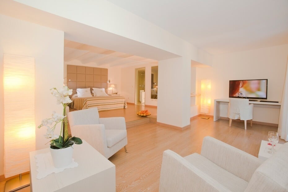 una habitación blanca con una cama y una televisión