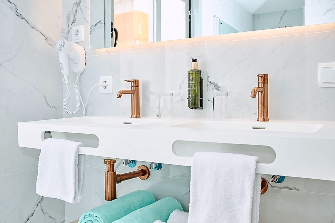 un baño con dos lavabos y un secador de cabello