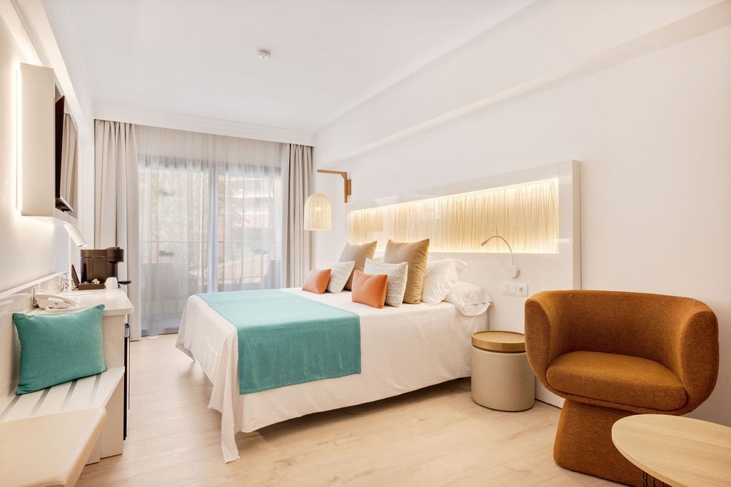 una habitación de hotel con dos camas y una pintura del océano en la pared .