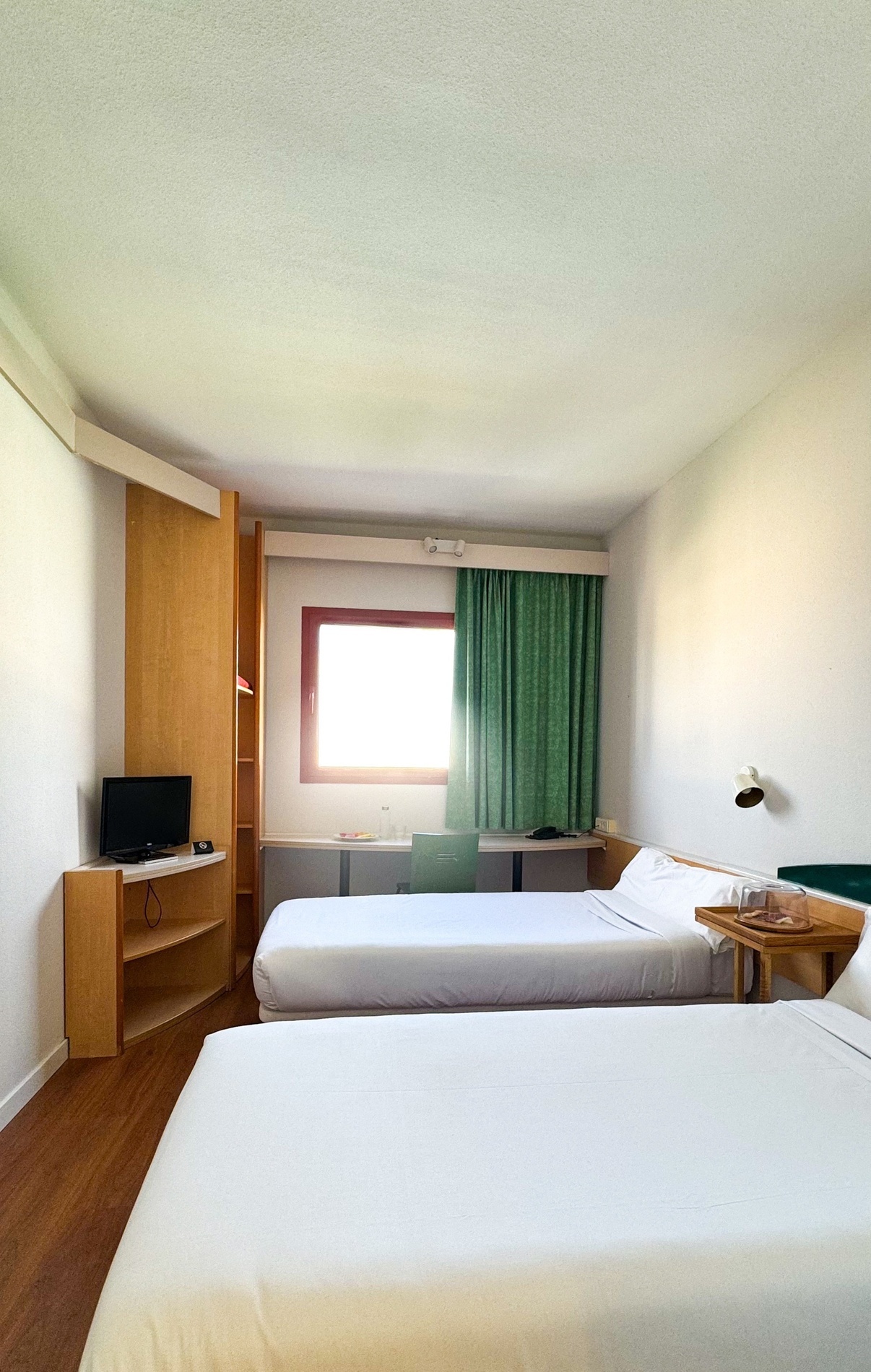 una habitación de hotel con dos camas y una televisión