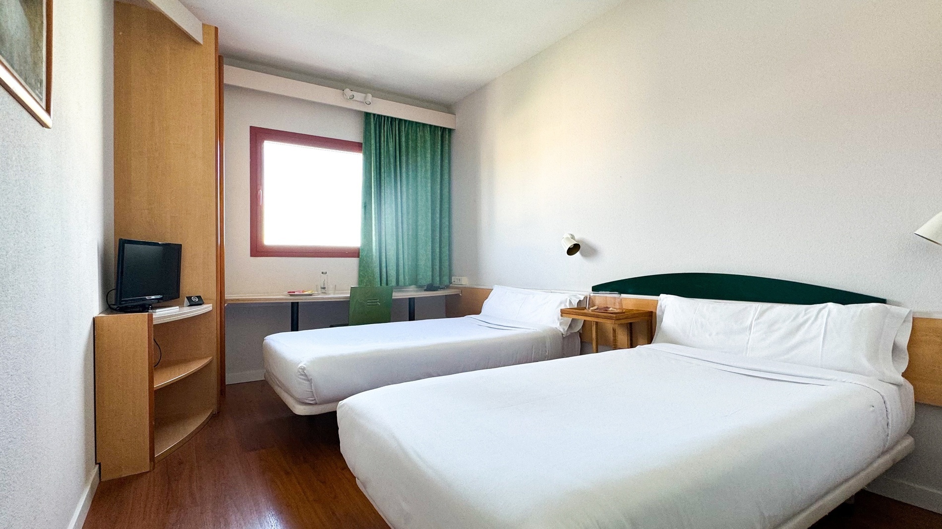 una habitación de hotel con dos camas y una televisión