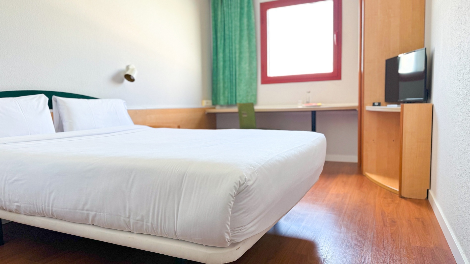 una habitación de hotel con una cama y una televisión