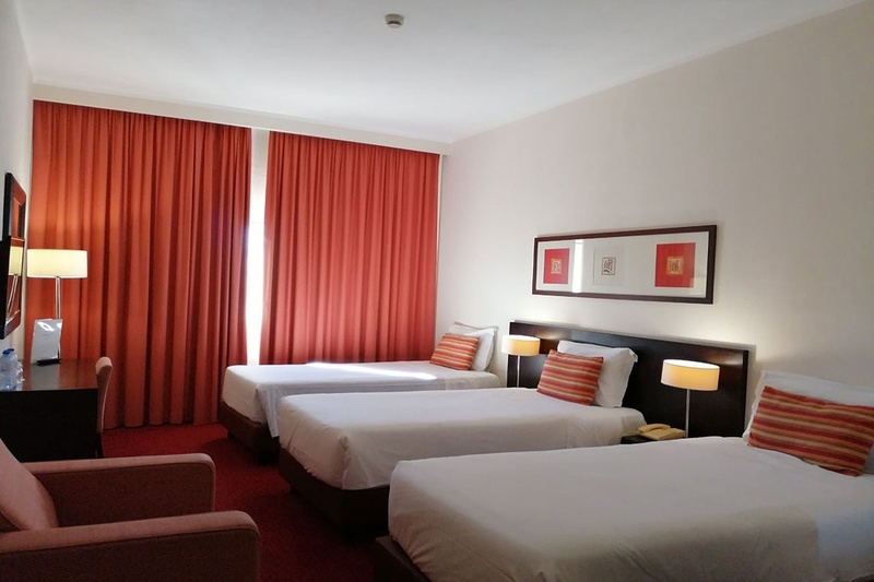 Quarto triplo no Hotel Monaco com três camas, decoração moderna e aconchegante.