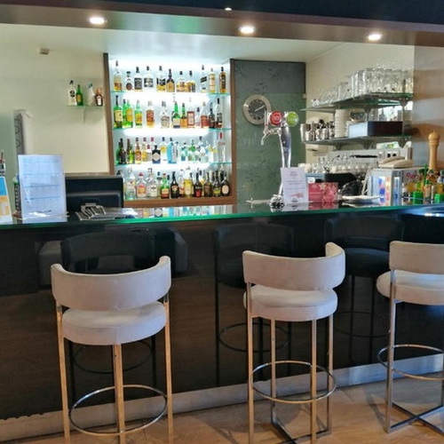 Bar y taburetes en Hotel Monaco: ideal para disfrutar de cócteles y ambiente sofisticado.