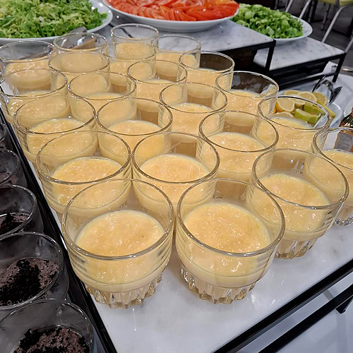Refeições no Hotel Monaco: mesas postas em salão elegante com buffet e decoração em tons de vermelho.