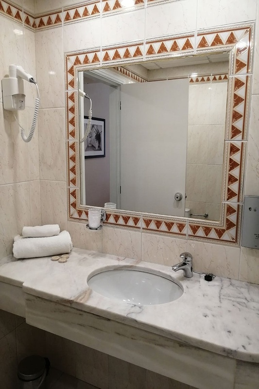 Quarto triplo no Hotel Monaco com três camas, decoração moderna e aconchegante.