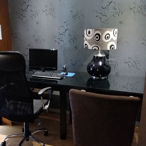 Escritorio moderno en Hotel Monaco con silla ergonómica y lámpara de diseño.