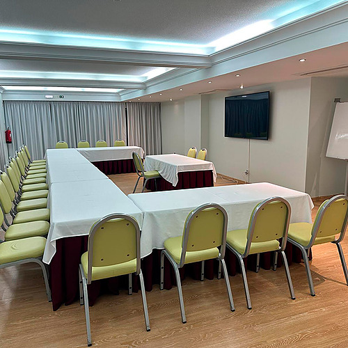 Sala de reuniões para hotel Hotel Monaco com mesas em U e cadeiras amarelas.
