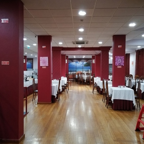 Amplio comedor del Hotel Monaco con mesas vestidas y suelo de madera.