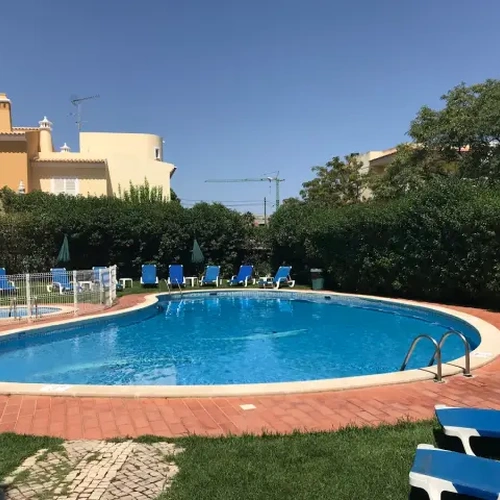 Piscina refrescante en el Hotel Monaco con tumbonas y exuberante vegetación.