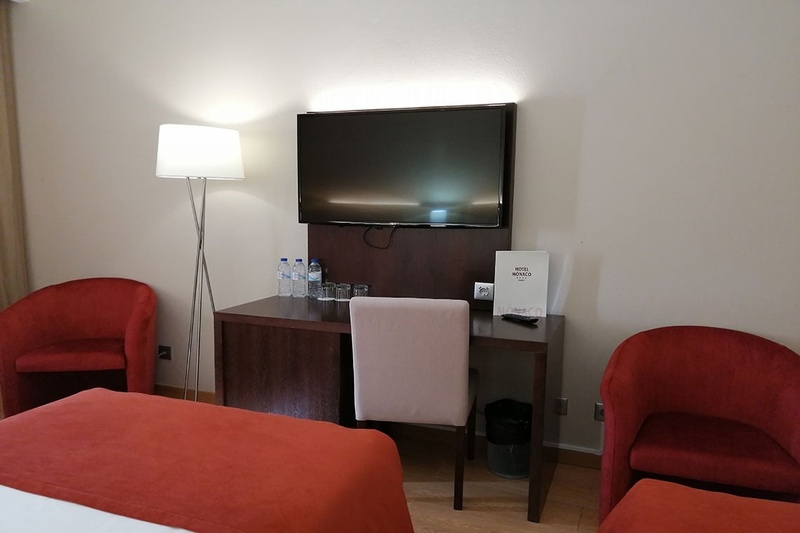 Quarto triplo no Hotel Monaco com três camas, decoração moderna e aconchegante.