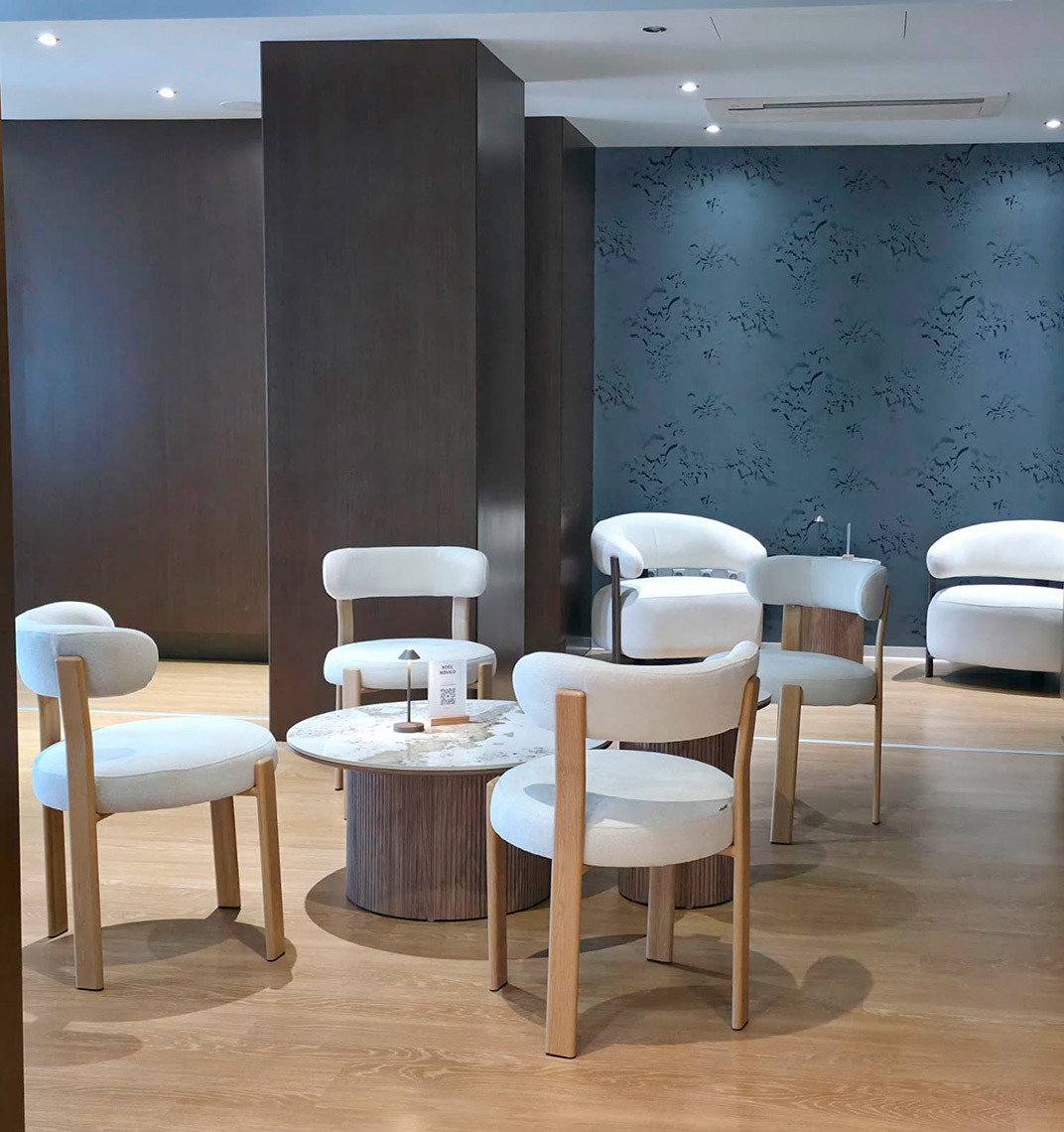 Lounge com cadeiras brancas Hotel Monaco e mesa de centro em mármore.