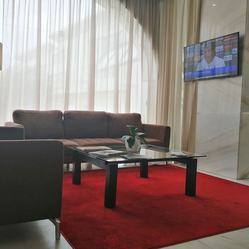 Relájese en la sala de estar del Hotel Monaco con sofás cómodos y una alfombra roja.