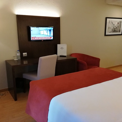 Habitación en Hotel Monaco con cama, escritorio y TV.