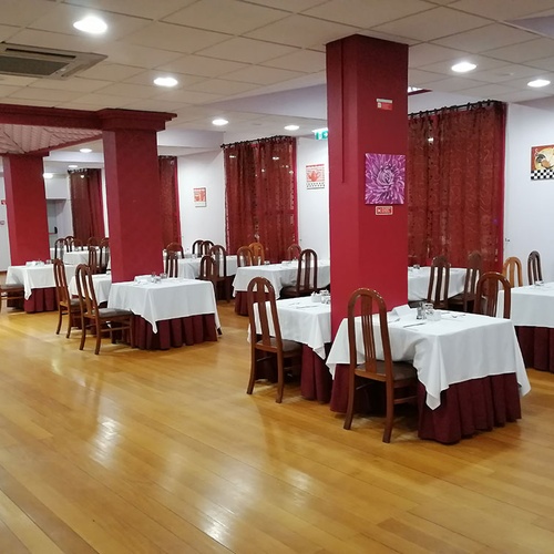 Comedor del Hotel Monaco con mesas vestidas y sillas de madera.
