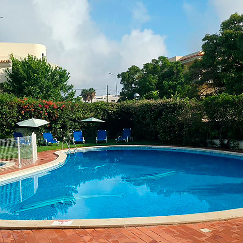Piscina de hotel brilhante com espreguiçadeiras e um jacuzzi. Ideal para umas férias relaxantes. Hotel Monaco