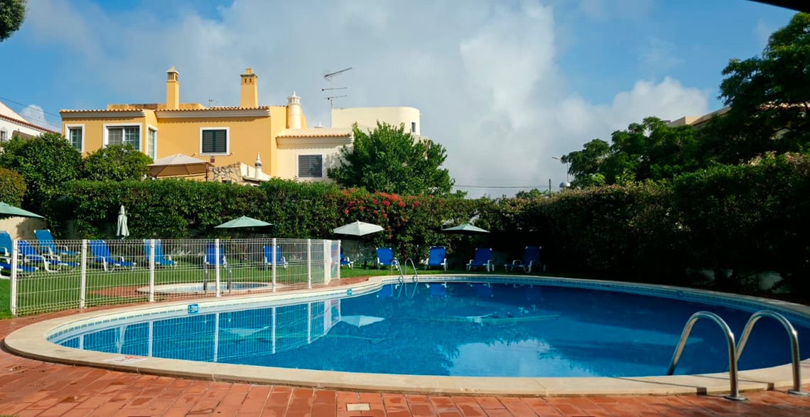 Piscina convidativa do hotel com espreguiçadeiras e área verde, perfeita para relaxar. Hotel Monaco.