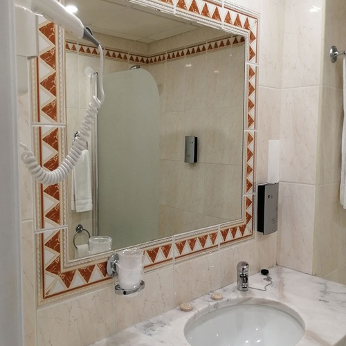 Baño moderno en Hotel Monaco con lavabo de mármol y espejo.