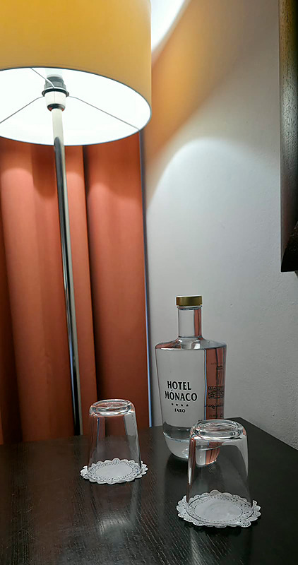 Quarto no Hotel Monaco com cama, poltronas e espelho grande.