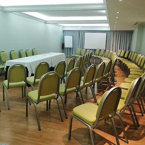 Salón de eventos con sillas amarillas dispuestas en círculo y mesa, ideal para Hotel Monaco.