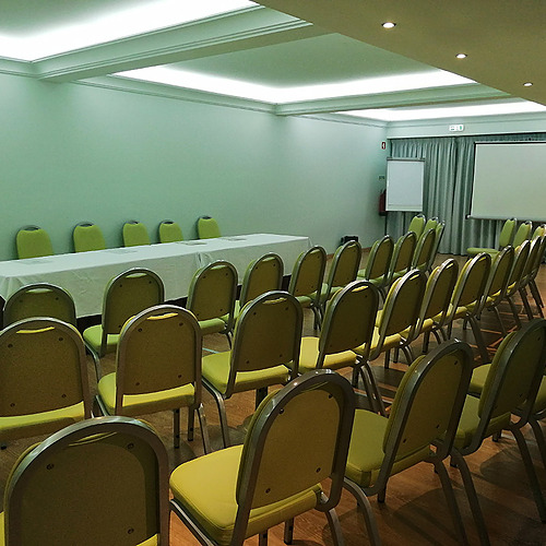 Sala de conferências para eventos em hotel, com cadeiras amarelas e mesas. Hotel Monaco