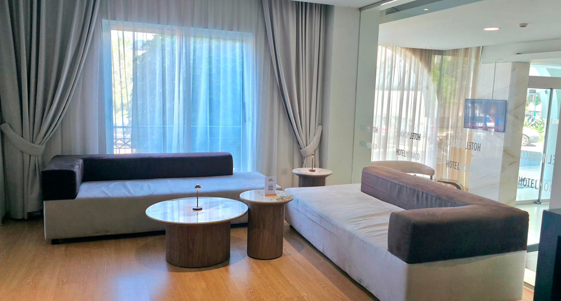 Sala de espera moderna com TV, poltronas e mesas de centro em um hotel. Hotel Monaco