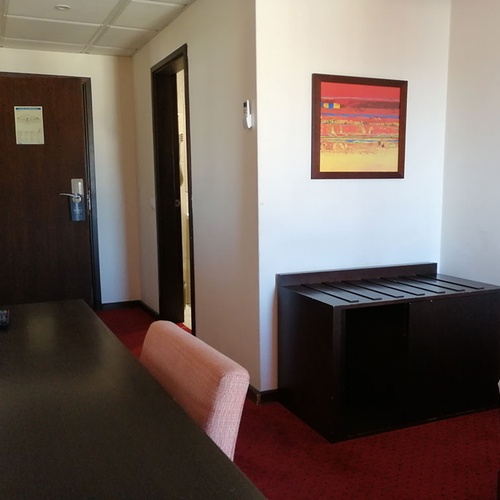 Habitación en Hotel Monaco con cama, escritorio y obras de arte.