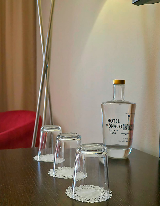 Quarto no Hotel Monaco com cama, poltronas e espelho grande.