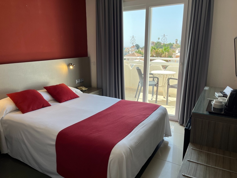 a hotel room with a large bed and a sliding glass door