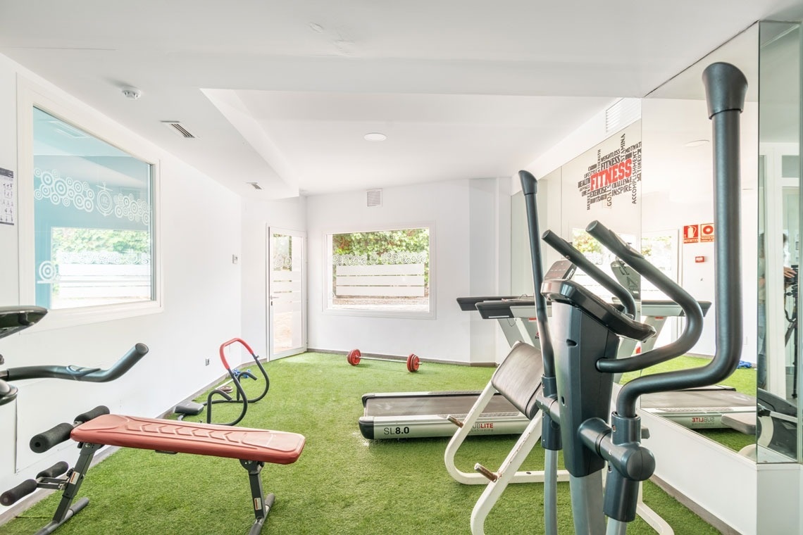 un gimnasio con equipos y una pared que dice fitness