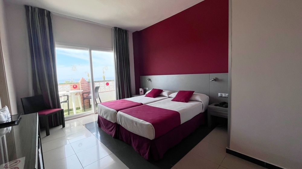 a hotel room with two beds and a balcony
