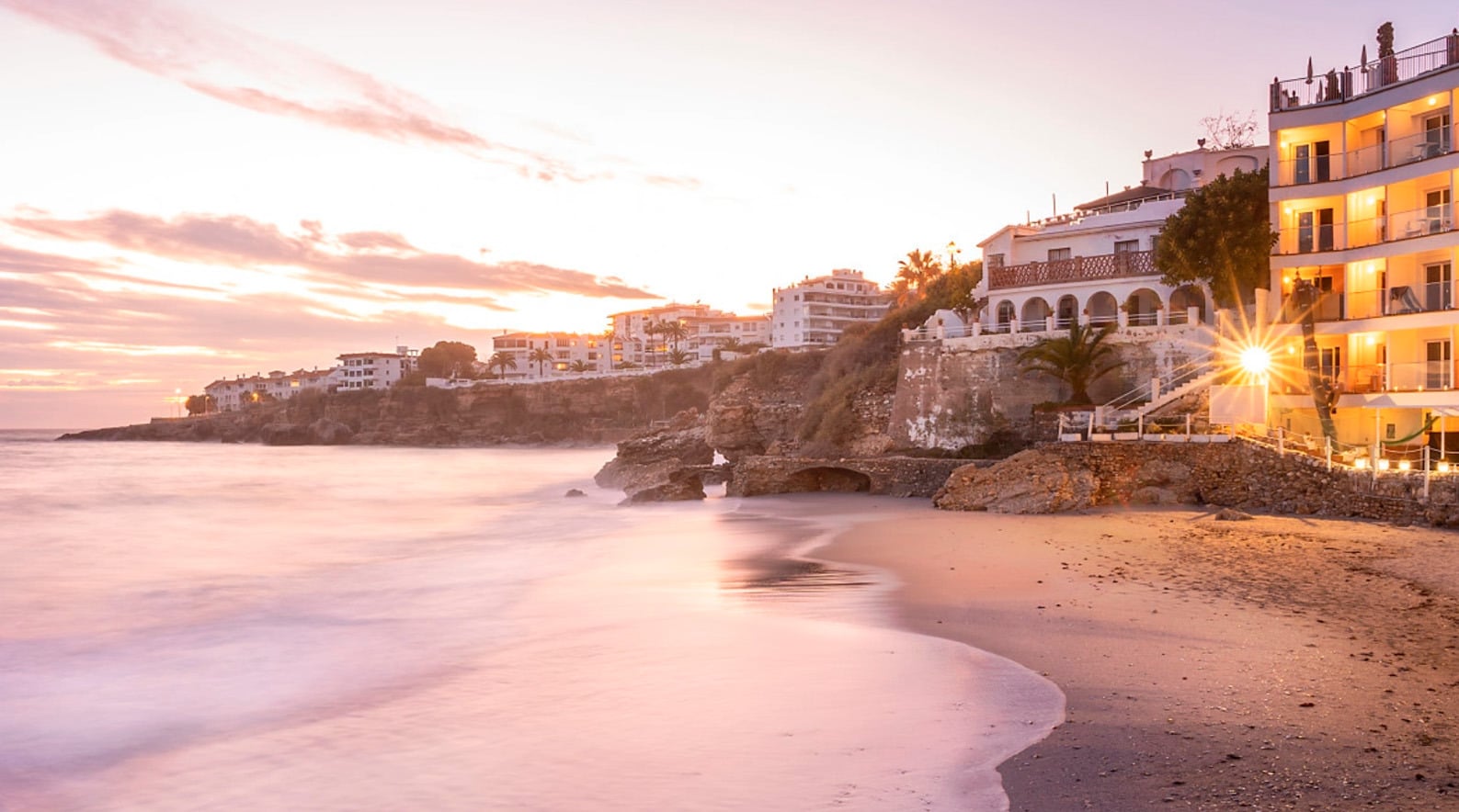 <p>	<strong>Hotel Nerja Club by Dorobe</strong></p> al atardecer en la playa, hotel de ensueño con vistas al mar y luces acogedoras.