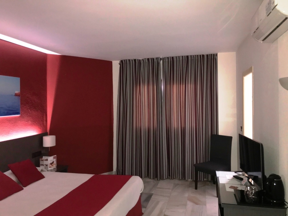 a hotel room with a bed and a television