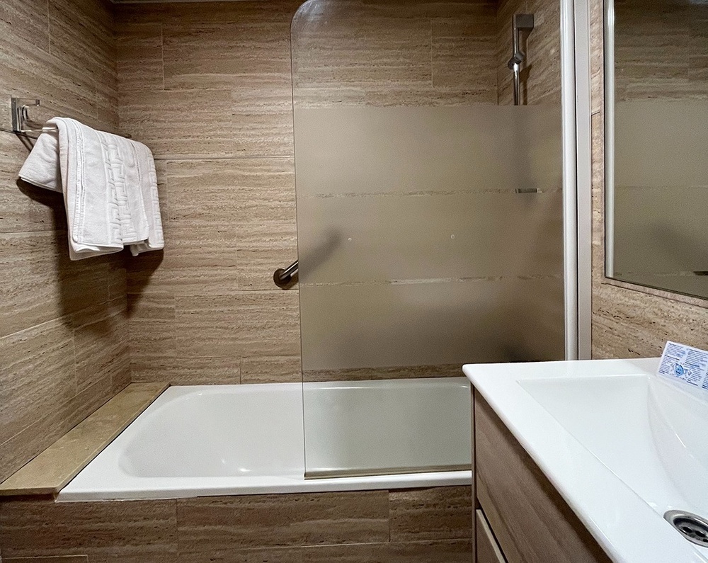 a bathroom with a bathtub and a glass shower door
