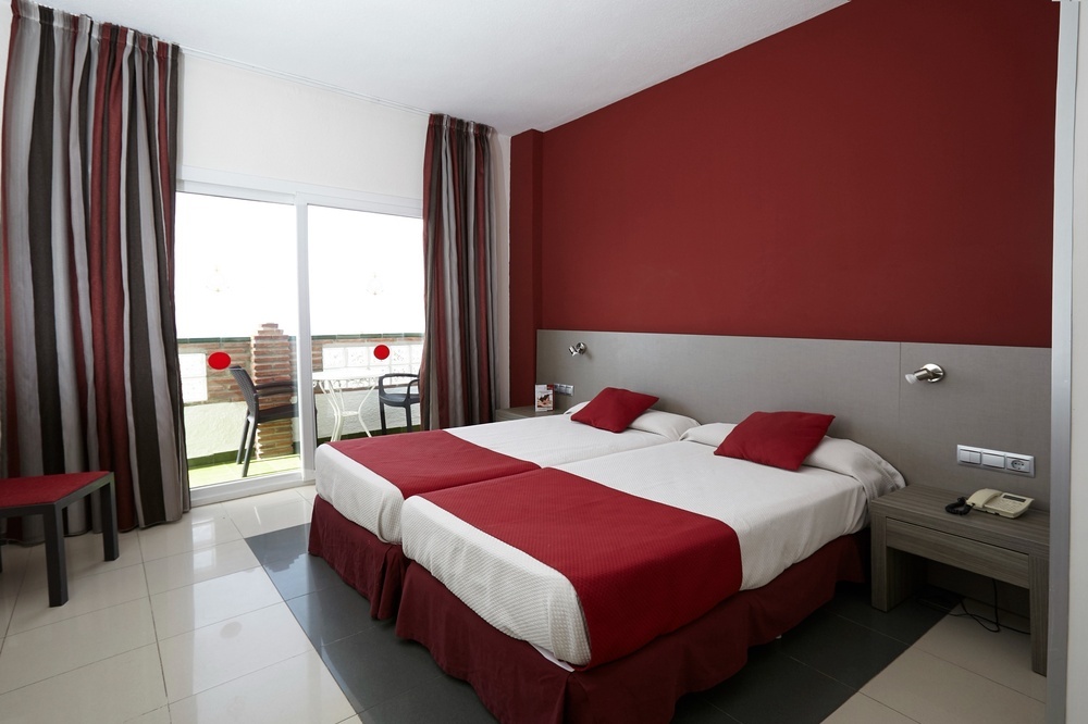 a hotel room with two beds and a balcony