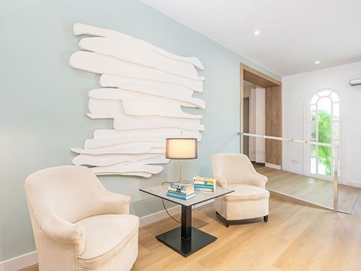 a living room with two chairs and a table with books on it