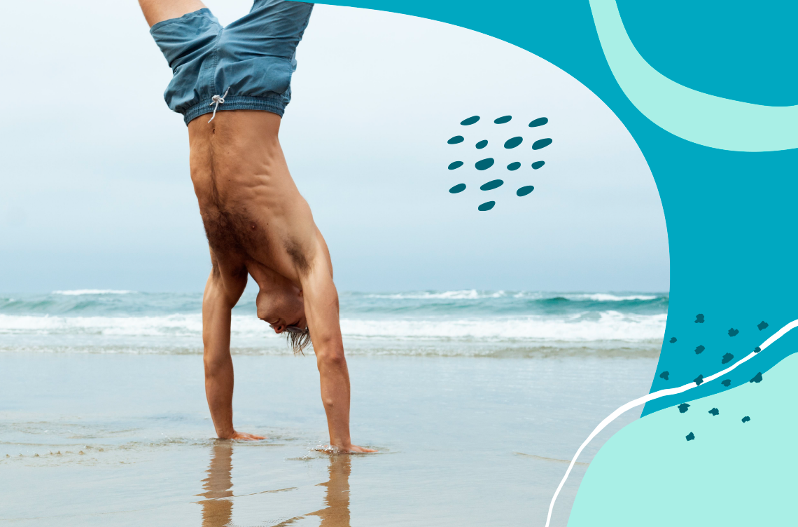 un hombre sin camisa hace un pino en la playa