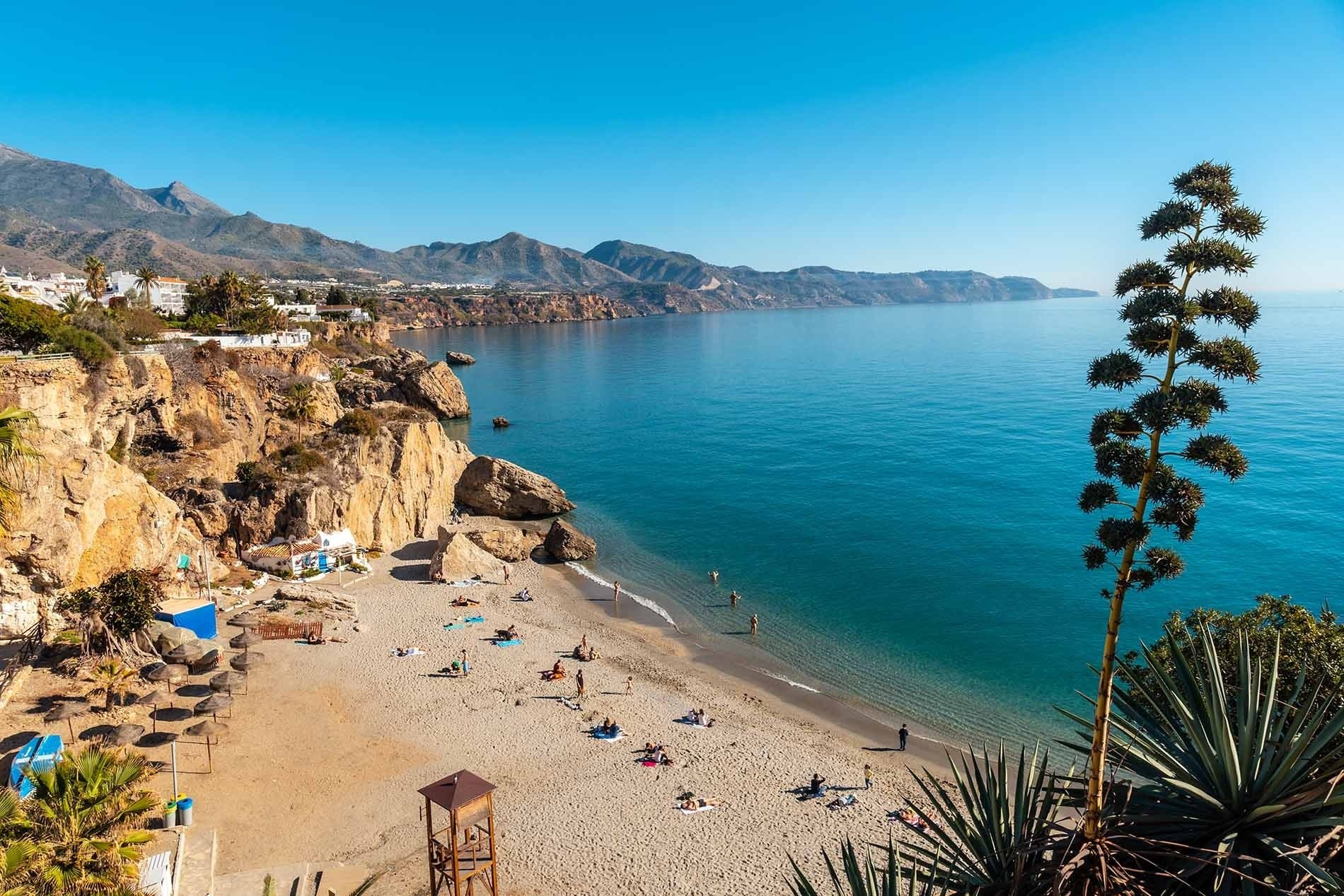 <p>	<strong>Hotel Nerja Club by Dorobe</strong></p> vista a la playa con aguas turquesas y montañas.