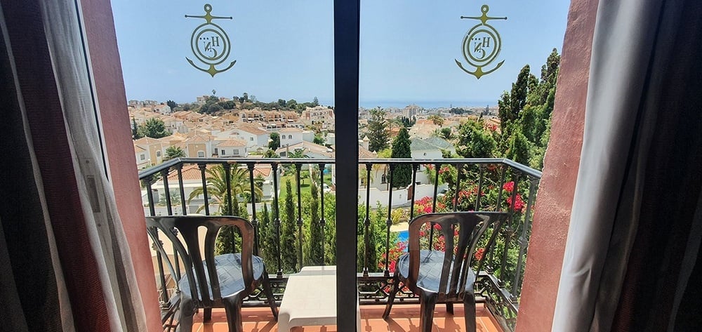 un balcón con dos sillas y un ancla en la puerta