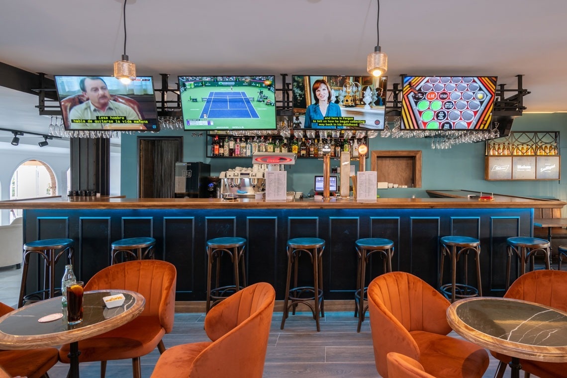 una pantalla en un bar muestra un partido de tenis