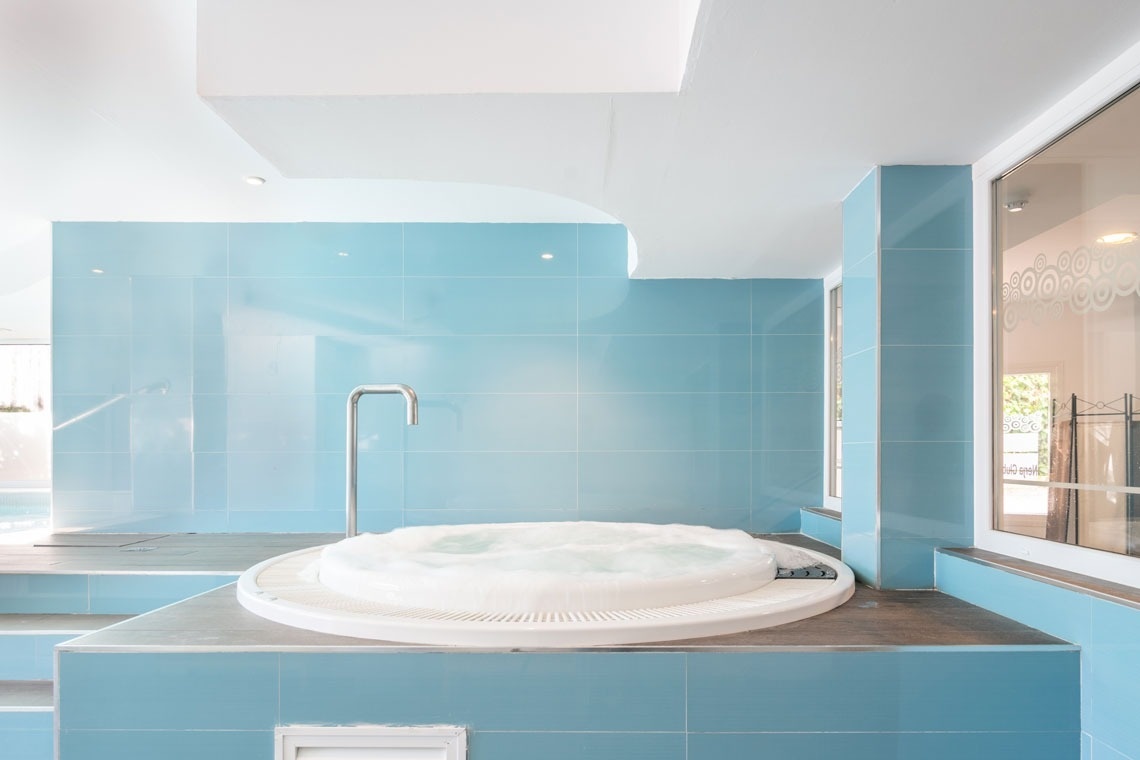 un jacuzzi en un baño con azulejos azules y blancos