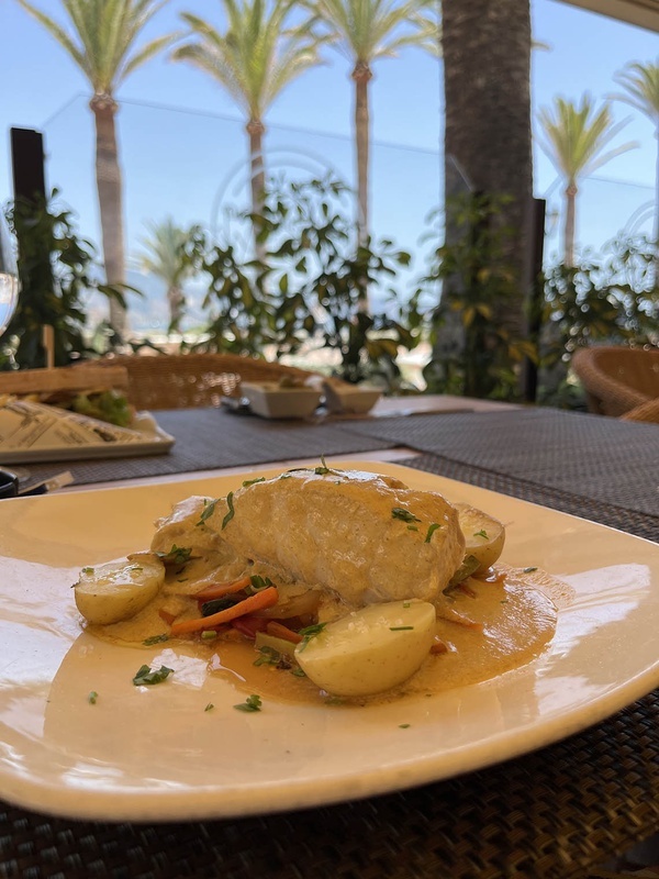un plato de comida en una mesa con palmeras en el fondo