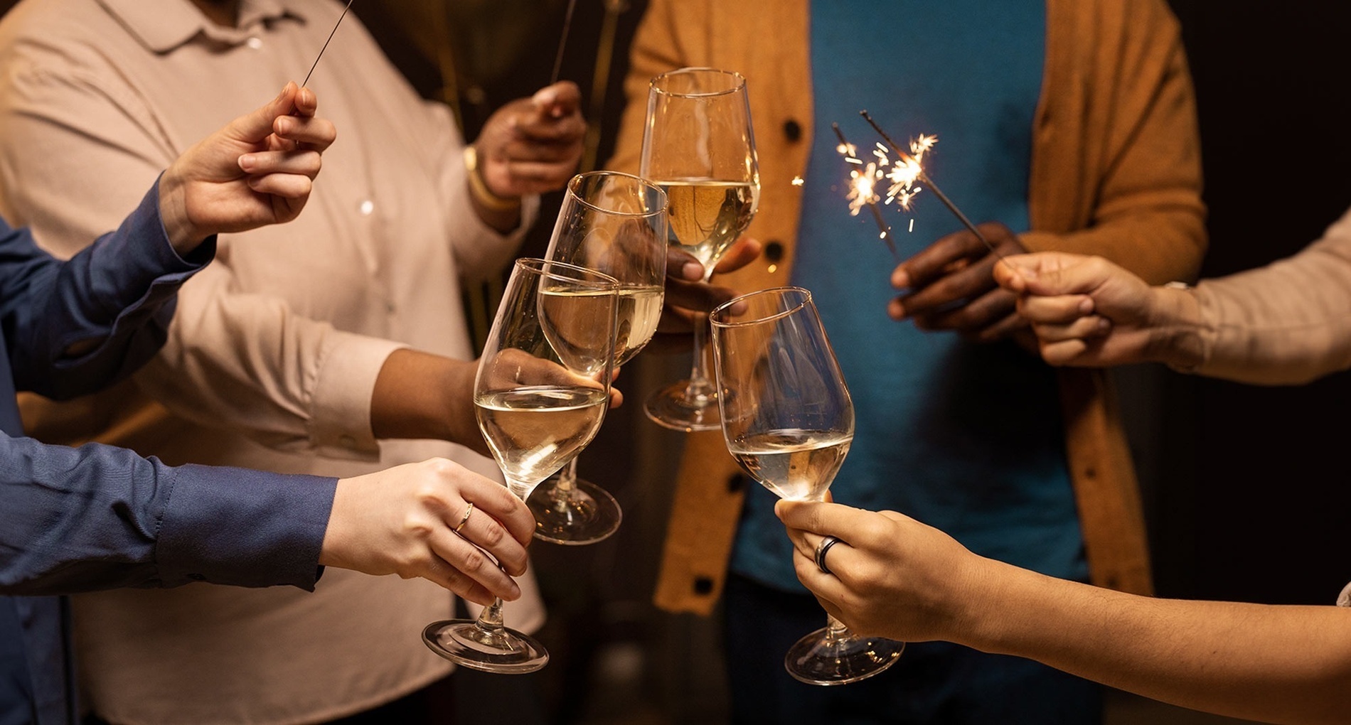 a group of people toasting with sparklers and wine glasses