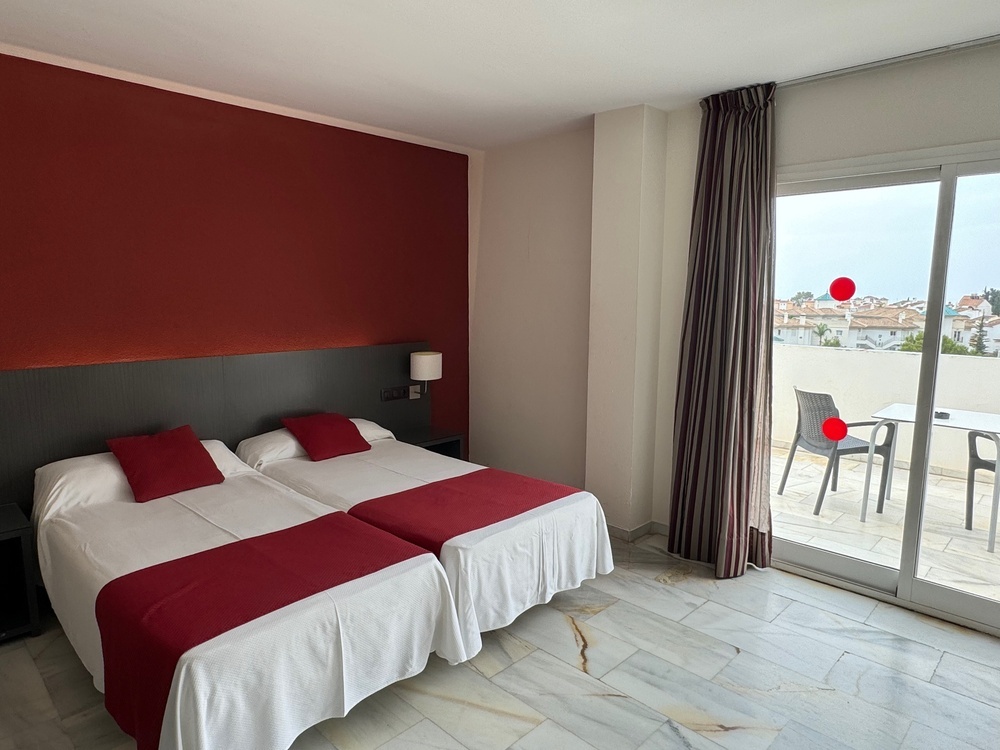 a hotel room with two beds and a sliding glass door