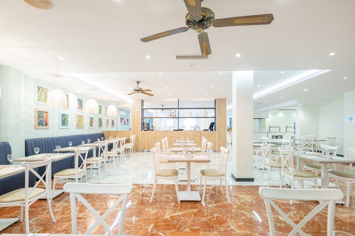 un restaurante con mesas y sillas y un ventilador de techo